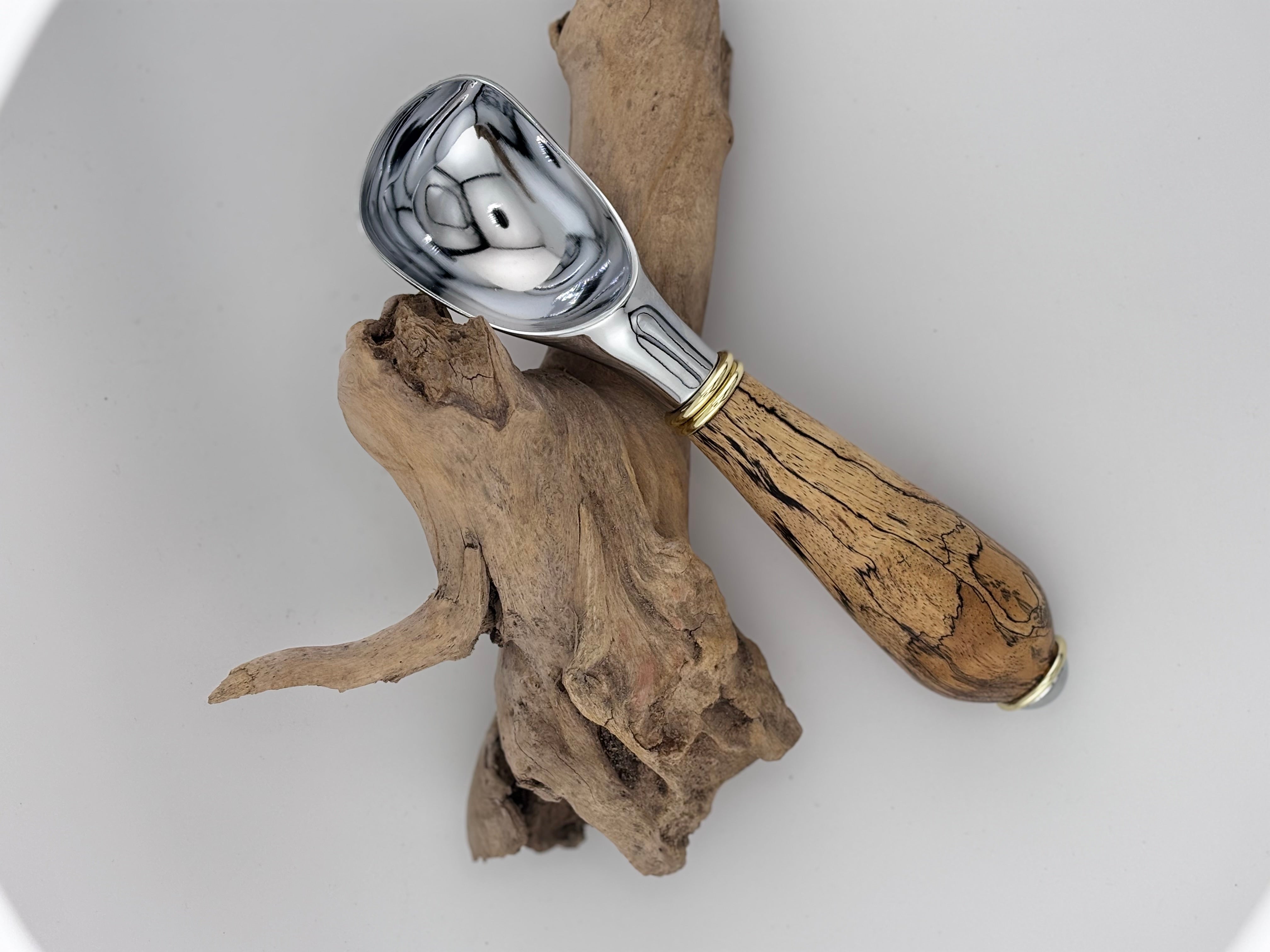 handmade wooden handled ice cream scoop displayed on driftwood